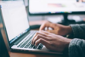 Person writing a blog, closeup on hands on the keyboard.